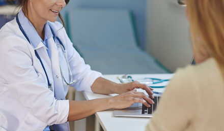 Mulher na menopausa conversando com sua médica sobre terapia de reposição hormonal.